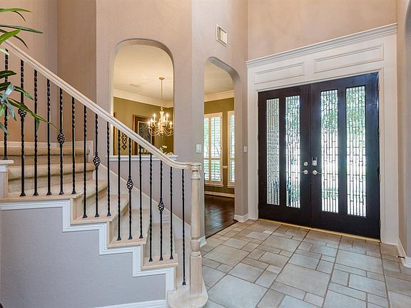 Gorgeous entry with soaring ceilings, handsome millwork, arched views in to the formal dining area, formal living room, family room and up the stairway with wood and wrought iron railings welcome you in to this wonderful home.