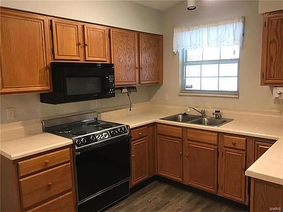 Kitchen features oak cabinetry in a full U Arrangement.  The window over the sink prep area overlooks the entry and approach to the property.   New vinyl plank wood look flooring has been installed.