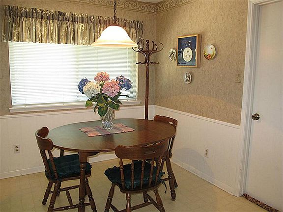 Charming breakfast area offers decorative valances & pretty light fixture.