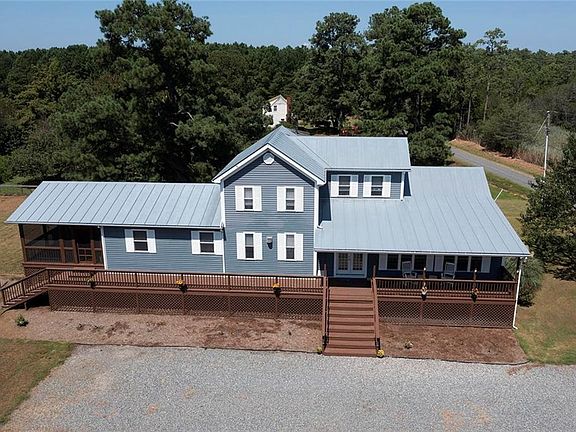 A 2006 house, raised 10 ft., offering a country front porch, side screened porch and above ground pool with a sun deck.