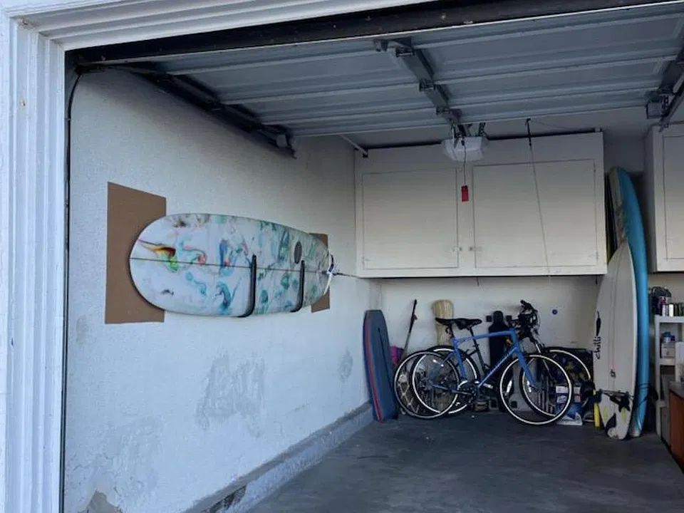 Garage parking for one car, with two storage cabinets and room for bicycles and surfboards