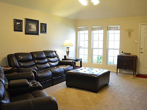 Large Family room. Features ceiling fan, neutral paint, faux wood blinds.
