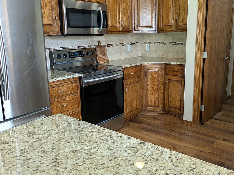 Kitchen with stainless steel appliances. The door leads to the laundry, pantry, and the garage.