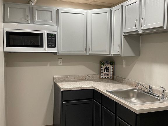 Brand new kitchen with bright, recessed lighting. Sink with sprayer. Brand new built in microwave with fan that vents to the outside.