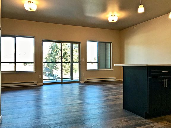 View of great room looking outside onto glass-fenced deck.