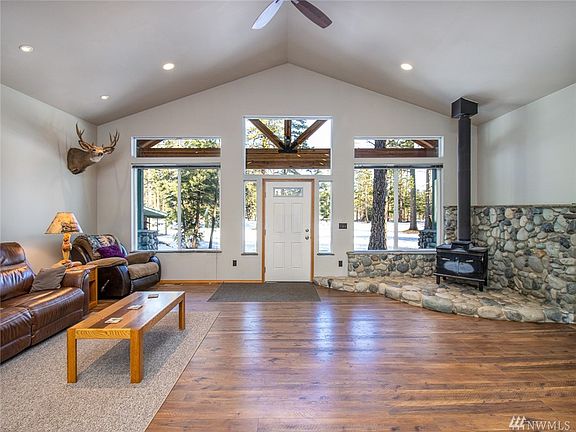 Beautiful great room! Vaulted ceilings, vinyl plank floors, & river rock fireplace with wood stove. Gorgeous windows to take in the winter view!