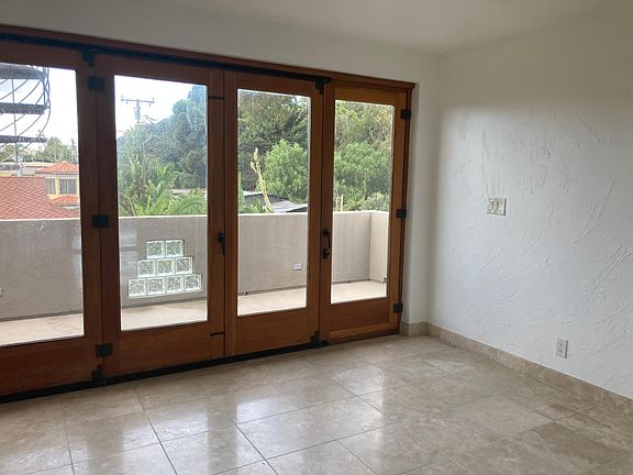 Master Bedroom: Fire Place, Five Bi-Fold Doors open to small deck. Master Bathroom within the Room. At left side of photo are the Spiral Stairs leading to the Roof Deck