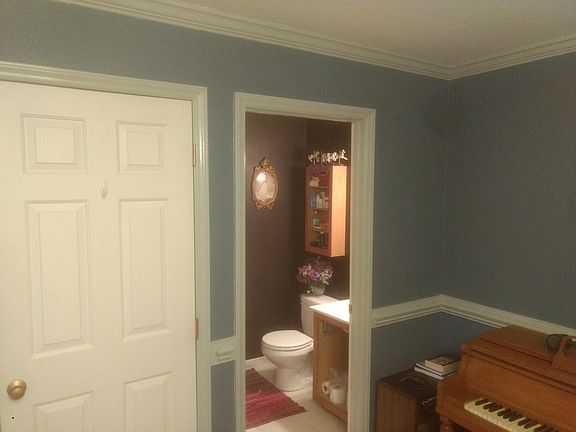 Half bath off the living room with coat closet next to it.