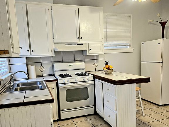 Kitchen includes gas stove, lots of cabinet space, refrigerator, tile floor and garbage disposal.