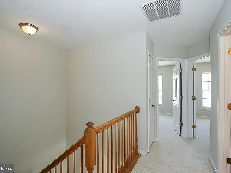 Upstairs landing, doors to second and third bedrooms, hall bathroom door, and hall closet door.