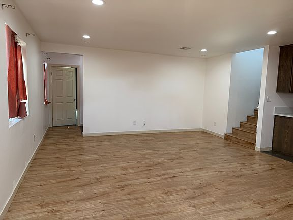 living room area, laundry space, staircase and first full bathroom