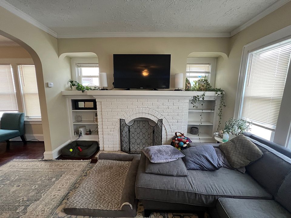 Large living room with built-ins and gorgeous white washed fireplace