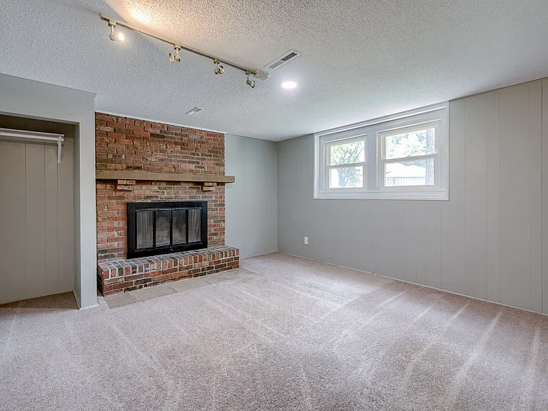 Bedroom4 (downstairs) features a nice fireplace, ceiling lighting, and two windows overlooking the front yard