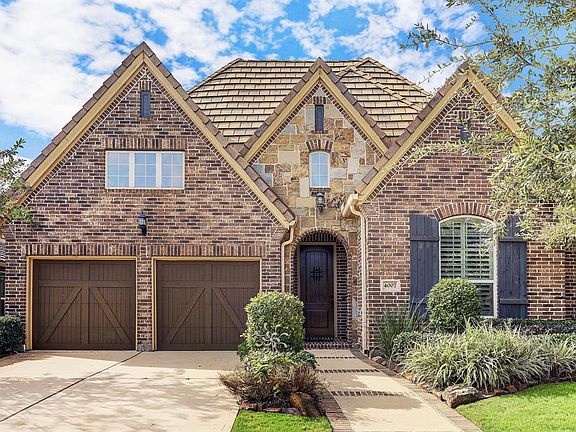 Stunning front elevation with brick and stone and a tile roof!