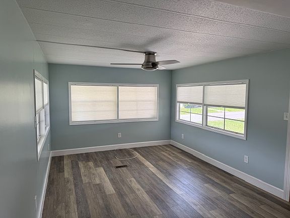 Living room with ceiling fan for comfort and all windows have retractable blinds
