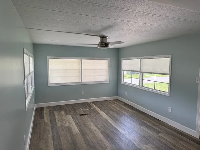 Living room with ceiling fan for comfort and all windows have retractable blinds