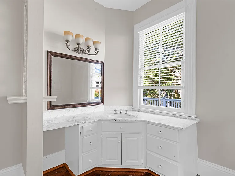 Vanity with Window Looking Out onto Private Second Floor Deck with Access via Door in Master Bedroom