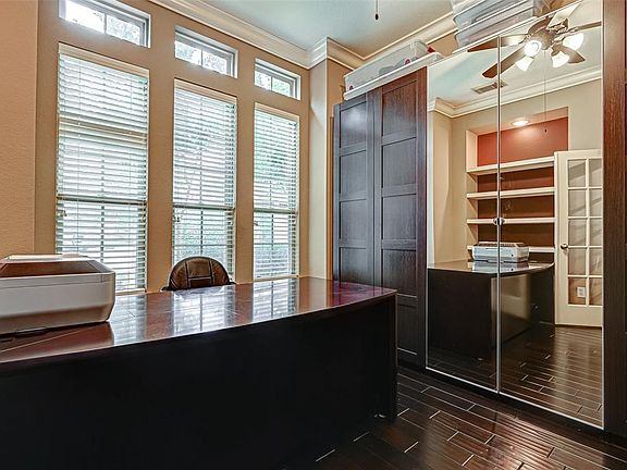 The spacious study offers dark, richly stained hardwoods, high ceilings with deep crown molding and a wall of windows. This room offers plenty of space for large, executive style furniture.
