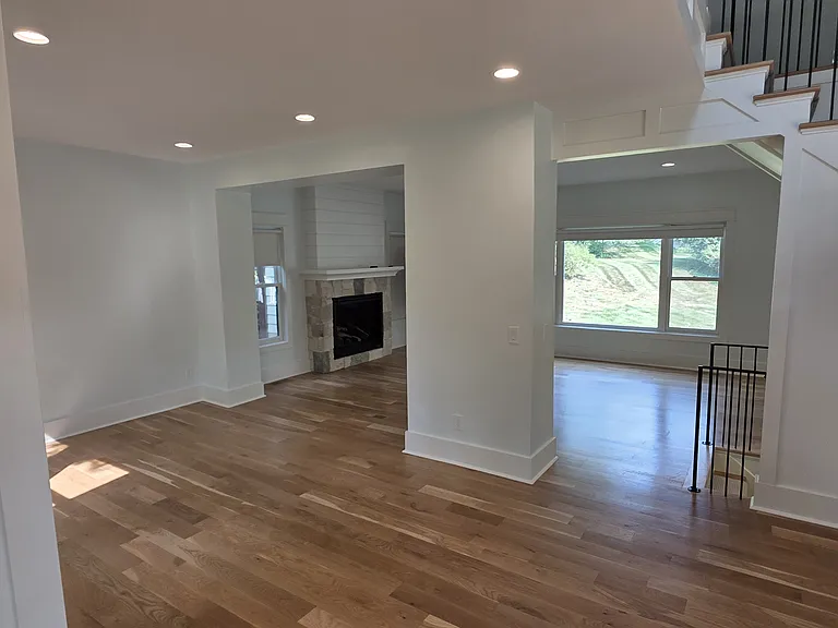 View from front of living area into living room. To left of front stair case going to upper floor.