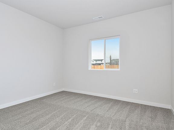 The master bedroom is spacious with a large window.