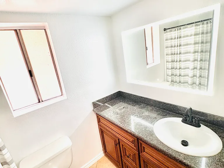 Modern bathroom featuring a Bluetooth-enabled smart mirror with built-in speakers, allowing you to play music while getting ready.