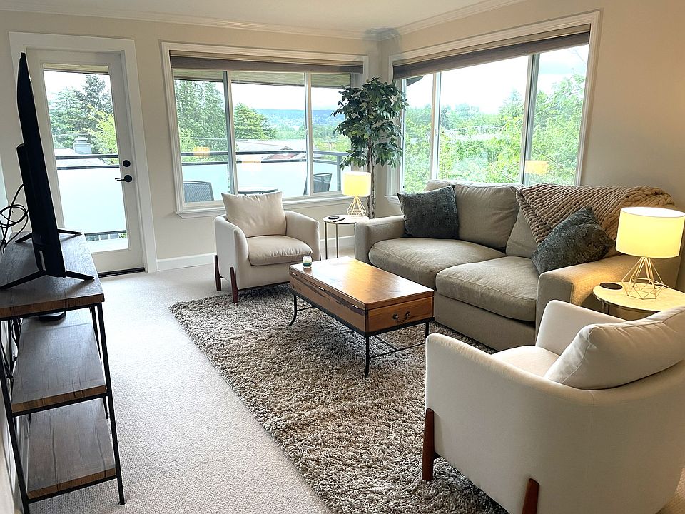 Living room includes super comfy couch, large television, deck access and scenic views.