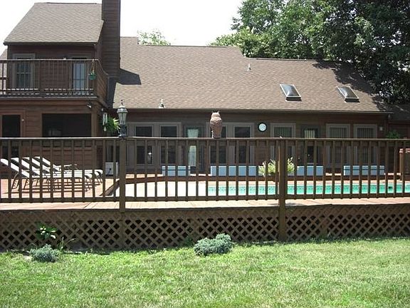 Large yard with inground pool and deck