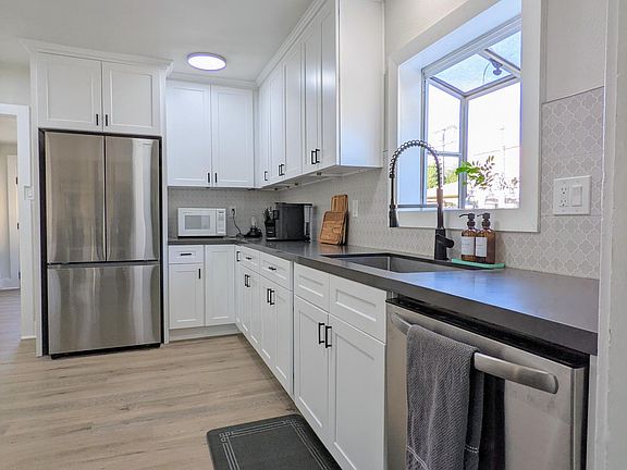 Kitchen with stove/oven, refrigerator, dishwasher, microwave, coffee machine, electric water kettle, cookware, dinnerware