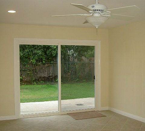 new sliding door, recessed lights, ceiling fan, and tile floor