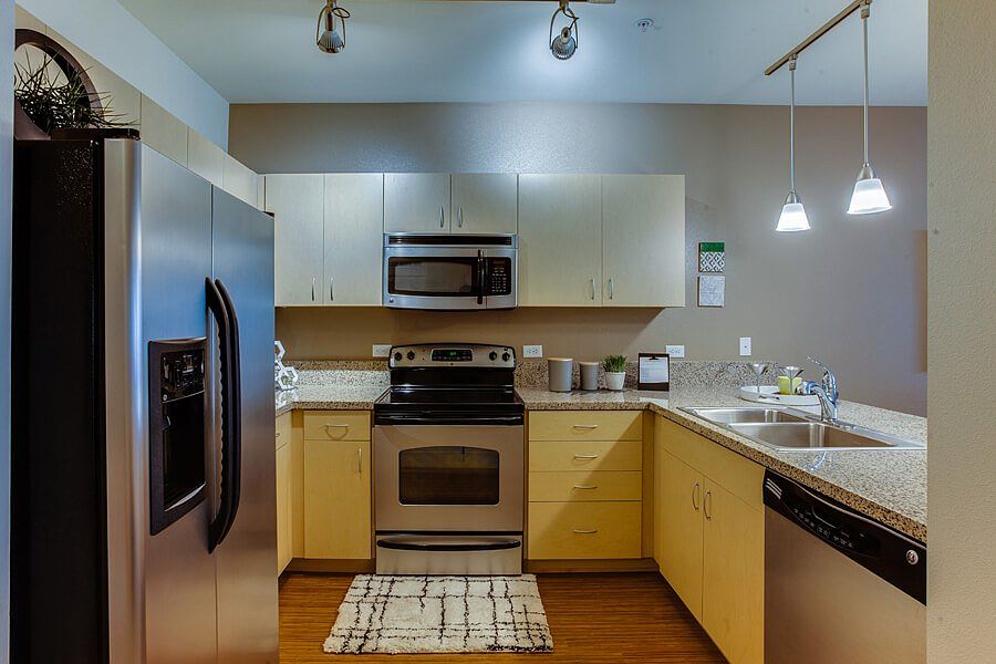Open kitchen features beautiful granite countertops with six inch granite backsplash and bamboo-finish plank flooring