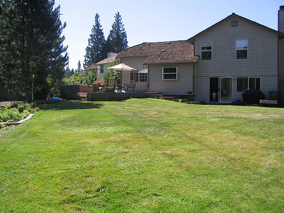 Large yard with deck and hot tub