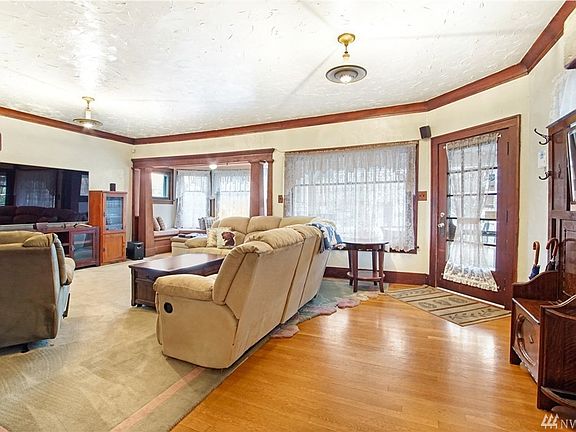 The oversize living room features wood trim, high ceiling, wood floor and lots of natural lighting.
