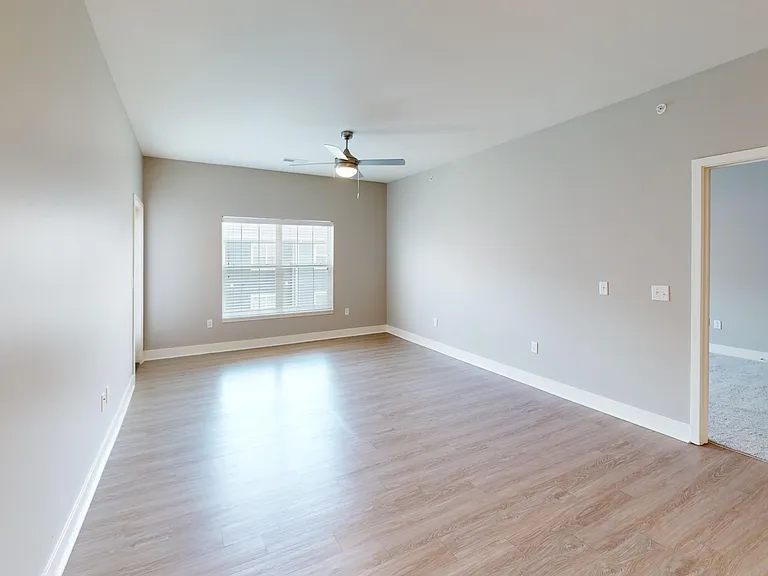 The Kraft features an open-concept layout with wood-style flooring, a large window, ceiling fan, and access to the private patio/balcony. The Kraft features an open-concept layout with wood-style flooring, a large window, ceiling fan, and access to the pr