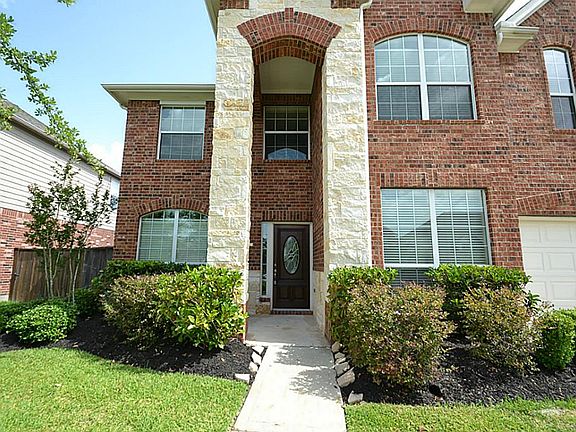 Front doorway with stone accents and a high arched entry inviting you inside.