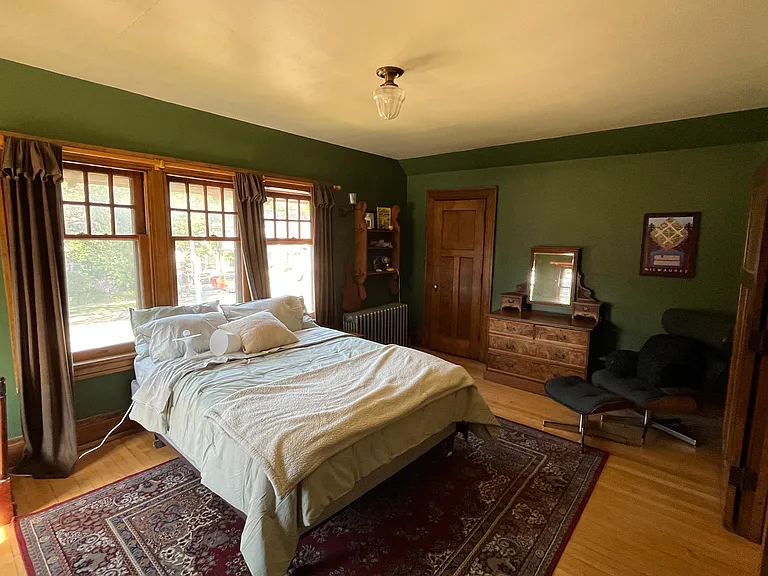 Massive front bedroom with brand new Queen size bed, dresser, desk, Eames chair, and two large closets