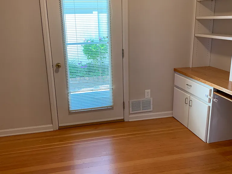 Front bedroom/office with exterior door leading to brick patio in private fenced in backyard