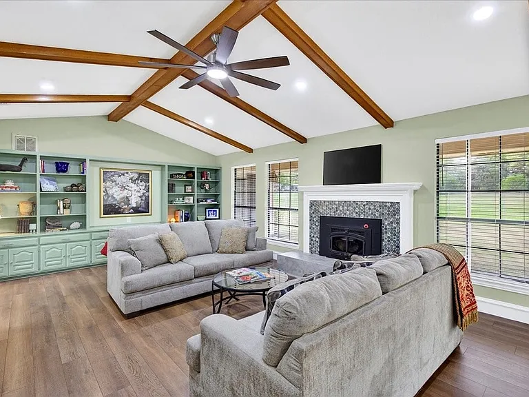 Storage and display space make this entertainment center the showstopper in your living room. Space in the middle for a large TV too. Vaulted ceiling with stained wood beams keeps this huge room warm and cozy.