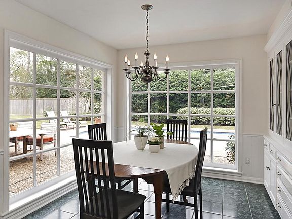BREAKFAST ROOM (13'x9') Natural light streams in through expansive floor to ceiling windows providing great views of the patio and pool area. Built-in glass front cabinets add to the lovely decor and provide additional storage.