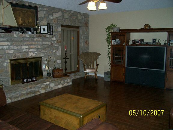 Large living area with a stone wall and fireplace