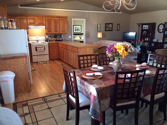 Looking into the home from the laundry room. The back door threshold is into the laundry room. Open living area floor plan. Cathedral ceiling and door to master bedroom in backgroumd.