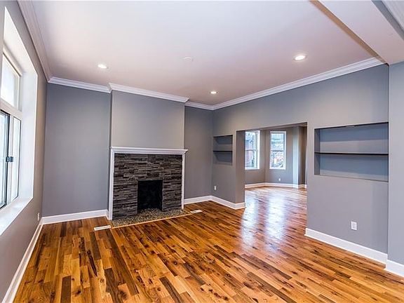 Living room area has a decorative fireplace with an innovative rock floor.   Built-in shelves to show off your favorite possessi