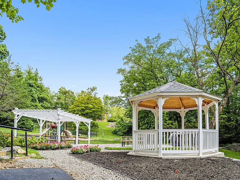 Enjoy the tranquility of this picturesque garden, featuring a classic gazebo and pergola.
