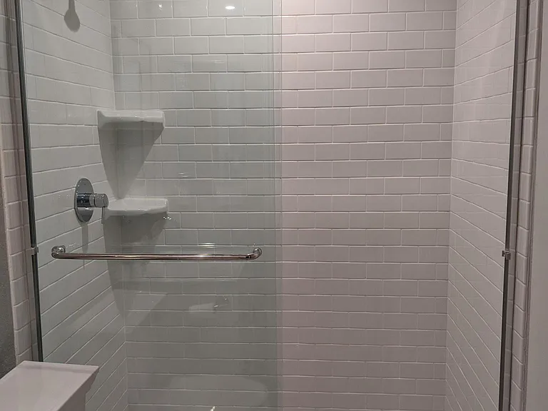 Master bathroom with walk in shower. Marble flooring, white subway tile to the ceiling. Medicine cabinet with mirror.