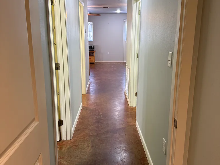 Hallway from doorway to larger bedroom looking into kitchen/living area
