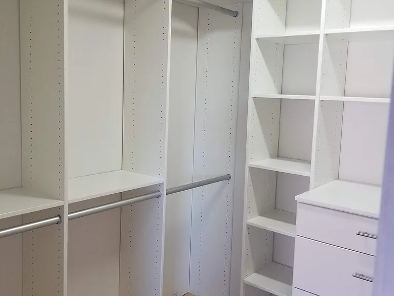 Primary bedroom walk-in closet w/ slide out tie and belt holders.