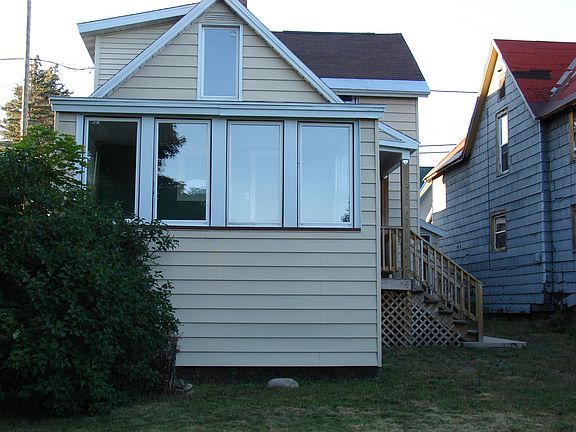 Back of home showing sunroom. Upper window is in non-conforming bedroom