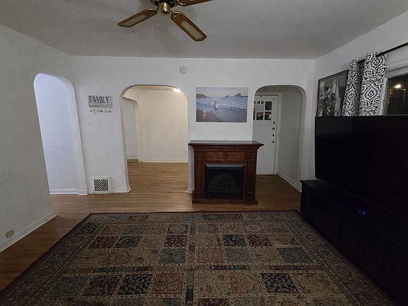 from west wall of living room toward hallway (left), dining room (center) and outdoor exit on 24th street