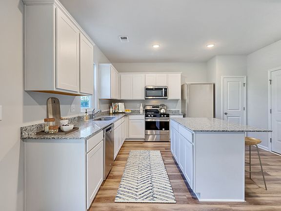The soft white lighting and classic white cabinets make this lovely kitchen perfect for preparing me