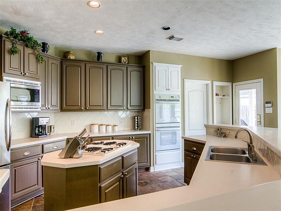 KITCHEN - This island kitchen has stainless and white appliances and plenty of cabinet and counter s