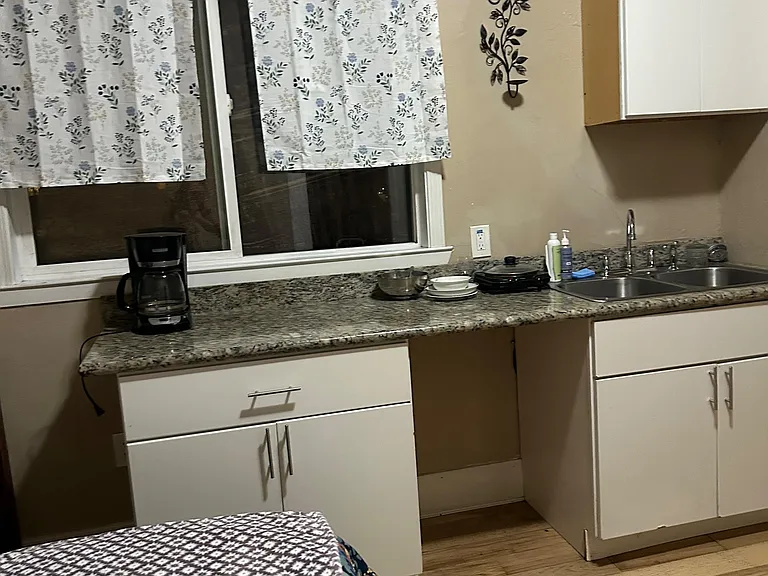 Compact kitchen area with granite-look counters, double sink, and upper/lower cabinetry for everyday storage and prep.